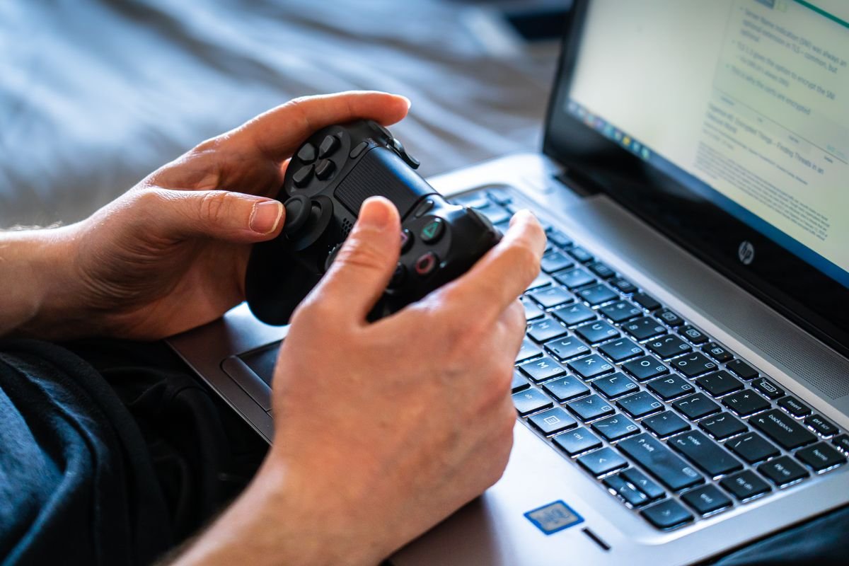 A gamer holding a controller while learning how to reduce lag in online games